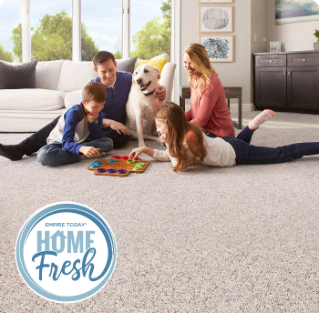 Happy family playing a game while sitting on cream colored odor-neutralizing Home Fresh Carpet